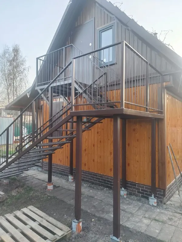Наружная металлическая лестница и балкон частного дома